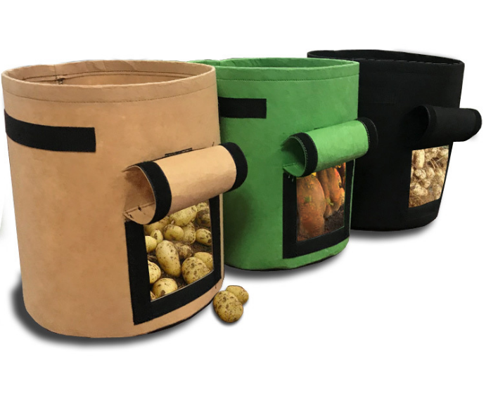 Three fabric potato grow bags with harvest windows showing potatoes
