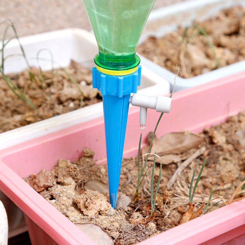 Automatic watering spike dripping into potted plant