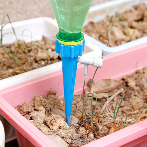 Automatic watering spike dripping into potted plant
