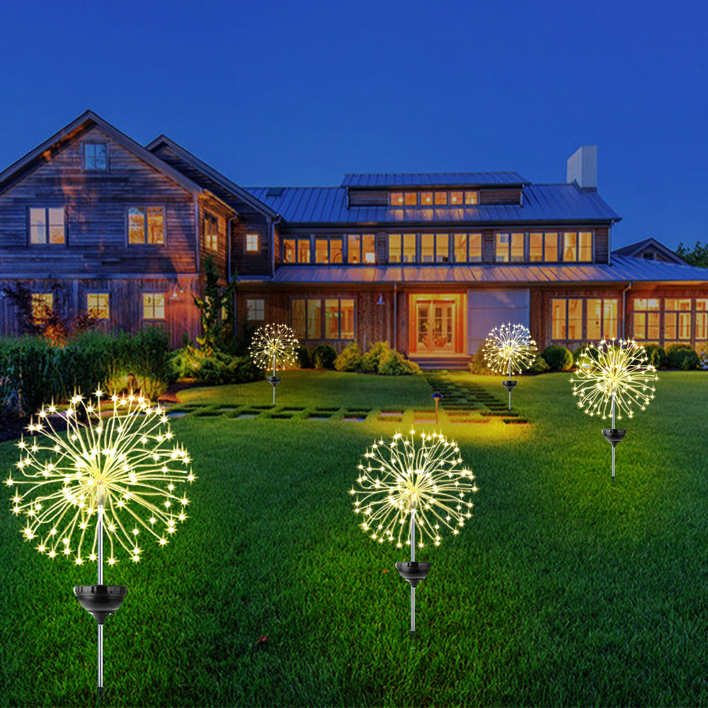 Solar firework lights glowing gold in garden at night