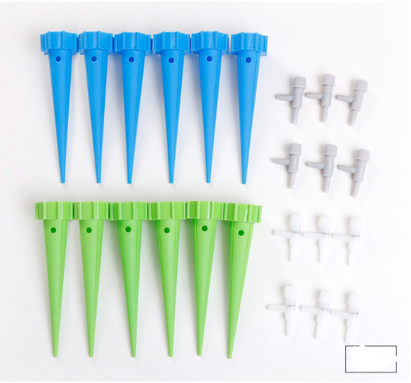 Watering spikes with bottle attached in planter