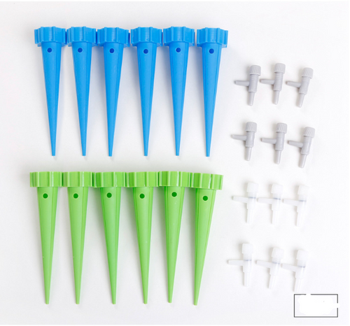 Watering spikes with bottle attached in planter