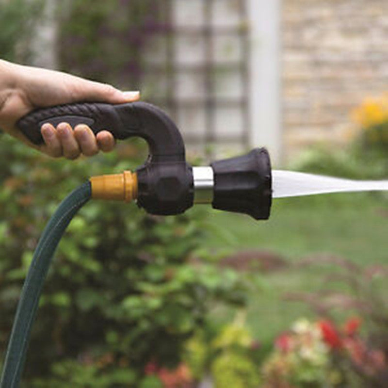 Hand using high-pressure hose nozzle to jet wash in a garden